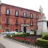 Siamo ora all�angolo di piazza Massari, dove incontriamo Palazzo Diana. Sede della banca della famiglia omonima fino al suo fallimento avvenuto a fine 800, ha un caratteristico colore rosso mattone e un portone dalla cornice di pietra bianca affiancato da quattro semicolonne della stessa tonalit�